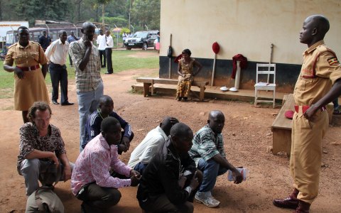 Hugh with fellow prisoners before prison officers. Photo: The Daily Monitor, Uganda